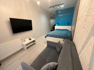 グダニスクにあるWyspa Spichrzów Residenceのベッドルーム1室(ソファ、テレビ付)