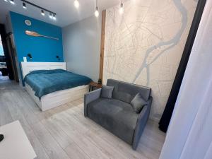 グダニスクにあるWyspa Spichrzów Residenceのベッドとソファと椅子のある寝室