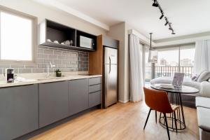 uma cozinha e sala de estar com uma mesa e um sofá em Charlie For You Moema em São Paulo