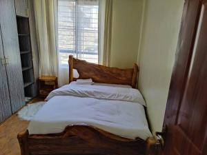 Bett in einem Zimmer mit Fenster in der Unterkunft Mupa's Luxury Condo I in Nyahururu