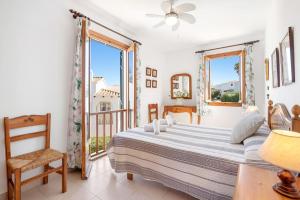 a bedroom with a bed and a balcony at Tina apartment in Port d'Addaia