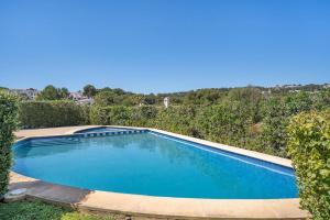 an empty swimming pool in a yard with bushes at Tina apartment in Port d'Addaia +23 photos