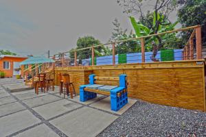 una terraza de madera con un banco y algunas mesas y sillas en Hidden gem en Kingston