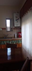 cocina con mesa, fregadero y ventana en La Luisa en Embalse