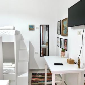 een witte kamer met een bureau en een stapelbed bij Ziu Guest House in Berat
