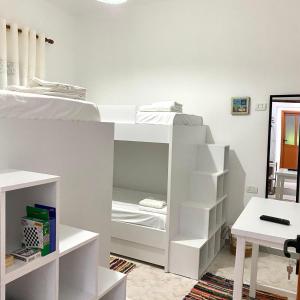a white bunk bed with white shelves in a room at Ziu Guest House in Berat