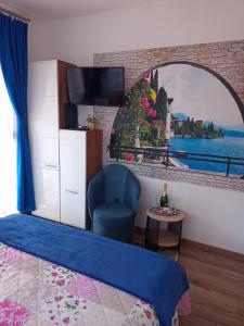 ハイドゥソボスローにあるRiviera Apartmanのベッドルーム(青い椅子、鏡付)