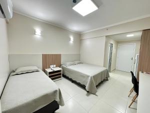 a hotel room with two beds and a window at Spazzio diRoma com acesso ao Acqua Park - Gabriel in Caldas Novas