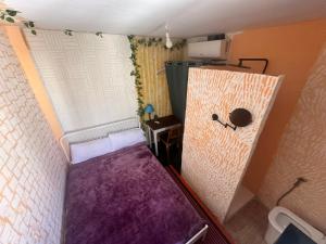 een kleine kamer met een paars matras en een raam bij Habitaciónes La JUNGLA 22 in Algeciras