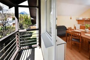 a room with a balcony with a table and a dining room at Apartmany ZEA in Tatranská Lomnica