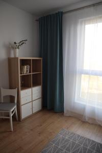 Habitación con estante de libros y ventana en Apartament na Ptasiej, en Gdansk