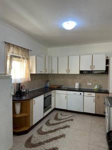 eine leere Küche mit weißen Schränken und einem Fenster in der Unterkunft Vila Sekulić in Podgorica