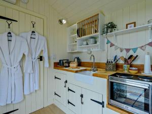 una cocina con toallas blancas colgadas en la pared en 1 Bed in Hoarwithy 93440 en Little Dewchurch