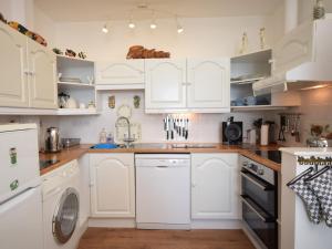 a kitchen with white cabinets and a dishwasher at 2 Bed in Ilfracombe CLOSE in Ilfracombe