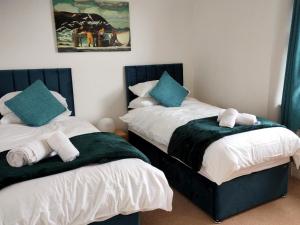 two beds sitting next to each other in a room at 2 Bed in Ilfracombe CLOSE in Ilfracombe