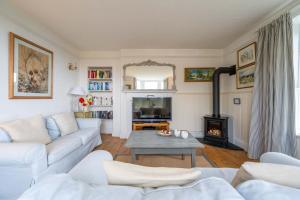 a living room with a white couch and a fireplace at Rosemary Cottage in Mortehoe