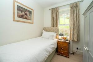 a small bedroom with a bed and a window at Rosemary Cottage in Mortehoe
