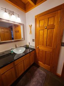W łazience znajduje się umywalka i lustro. w obiekcie Blacktail Cabin Hideaway with hot tub w mieście Lakeside
