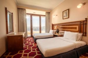 um quarto de hotel com duas camas e uma janela em Om Kolthom Hotel no Cairo