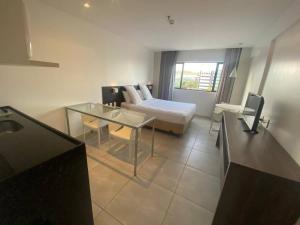une chambre d'hôtel avec un lit et une table en verre dans l'établissement Lindo Apto beira-mar no Condomínio do Hotel Ritz Suítes Home Service, à Maceió 12 autres photos