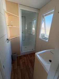 a bathroom with a shower and a sink and a window at MOBIL HOME LUCKY climatisé camping NOVELA PORT LA NOUVELLE in Port-la-Nouvelle