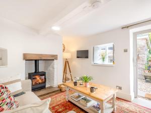 a living room with a fireplace and a table at 1 Bed in Hay-on-Wye 93134 in Bacton