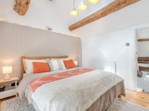 a bedroom with a large bed with orange pillows at 1 Bed in Hay-on-Wye 93134 in Bacton