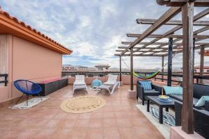 een patio met stoelen en tafels op een dak bij Blue Star Villa in Lajares
