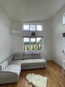 a living room with a couch and a window at Ett nytt fräsch hus utanför Stockholm nära Arlanda in Rosersberg