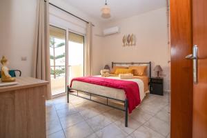 a bedroom with a bed with a red blanket at Rodini Sun Apartment in Rhodes Town