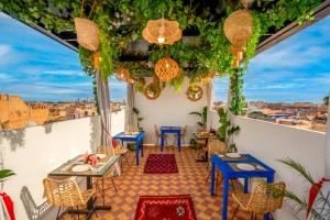a balcony with tables and chairs and a view of the city at Riad Samir Privilege Boutique Hotel & Spa in Marrakech