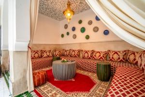 a red couch with a table in a room at Riad Samir Privilege Boutique Hotel & Spa in Marrakesh