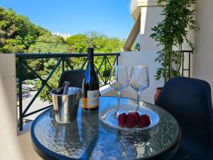un tavolo con due bicchieri e una bottiglia di vino di Rodini Sun Apartment a Città di Rodi