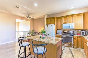 a kitchen with wooden cabinets and a island with bar stools at Entire Private 12-Guest 3-Bedroom Townhouse with Garage near San Diego Gaslamp in National City