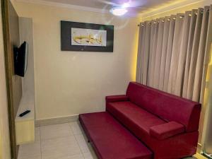 un soggiorno con divano rosso in una camera di Lacqua Diroma 12345 R1 a Caldas Novas