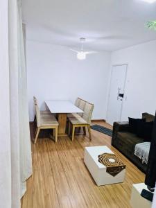 een woonkamer met een tafel en een bank bij Aconchegante in Campo Grande