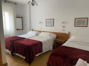 バイヨーナにあるHotel Carabela La Pintaのベッド2台と鏡が備わるホテルルームです。