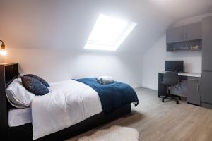 a bedroom with a bed and a desk and a window at Modern Studio: Old Trafford in Manchester