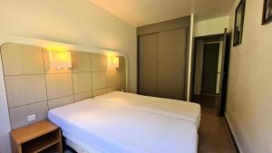 1 dormitorio con 1 cama blanca con luces en la pared en Residence De La Foret - 2 Pièces pour 5 Personnes 86 en Flaine