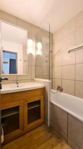 y baño con lavabo, bañera y espejo. en Residence De La Foret - 2 Pièces pour 5 Personnes 86 en Flaine