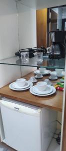 a counter with white plates and bowls on it at Nallah ApartHotel in Natal