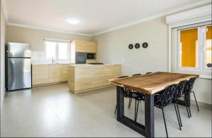 a kitchen with a wooden table and a refrigerator at Island Oasis Villa in Noord