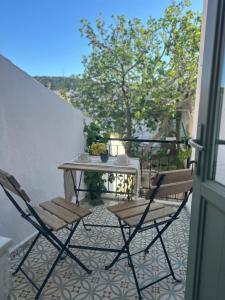 a patio with a table and chairs on a balcony at Kidoni Macaron Guesthouse in Ayvalık