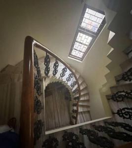 a spiral staircase with a mirror and a window at Devka villa in Daman