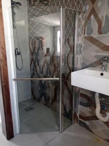 una ducha con una puerta de cristal junto a un lavabo en Studio flat 7A en Hamrun