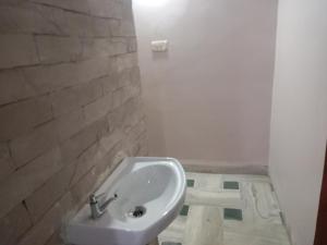 a bathroom with a sink and a brick wall at Devka villa in Daman