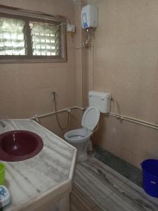 a bathroom with a sink and a toilet at Devka villa in Daman