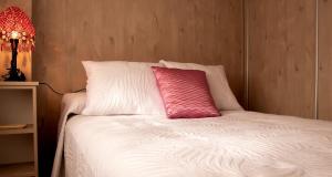 almohada rosa sobre la cama en Casa rural El Tejar en Villacarrillo