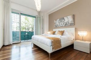 - une chambre avec un lit blanc et une grande fenêtre dans l'établissement Nest of Elegance - 5 minuti dalla stazione -, à La Spezia