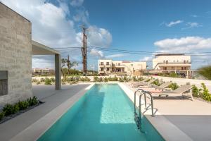 a swimming pool with lounge chairs next to a building at Deux Olives Luxurious & Quality Villa in Módhion